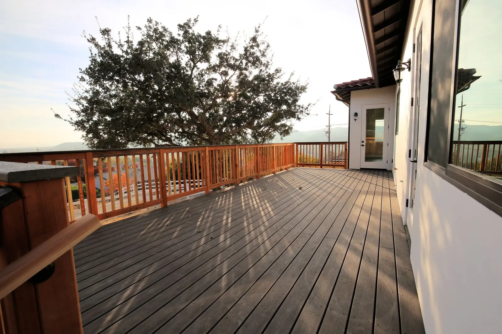 Composite wood deck with a cedar railing at sunset