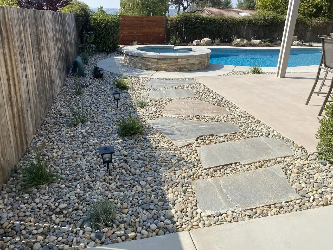 Concrete stepping pads set in river rock with low path lights