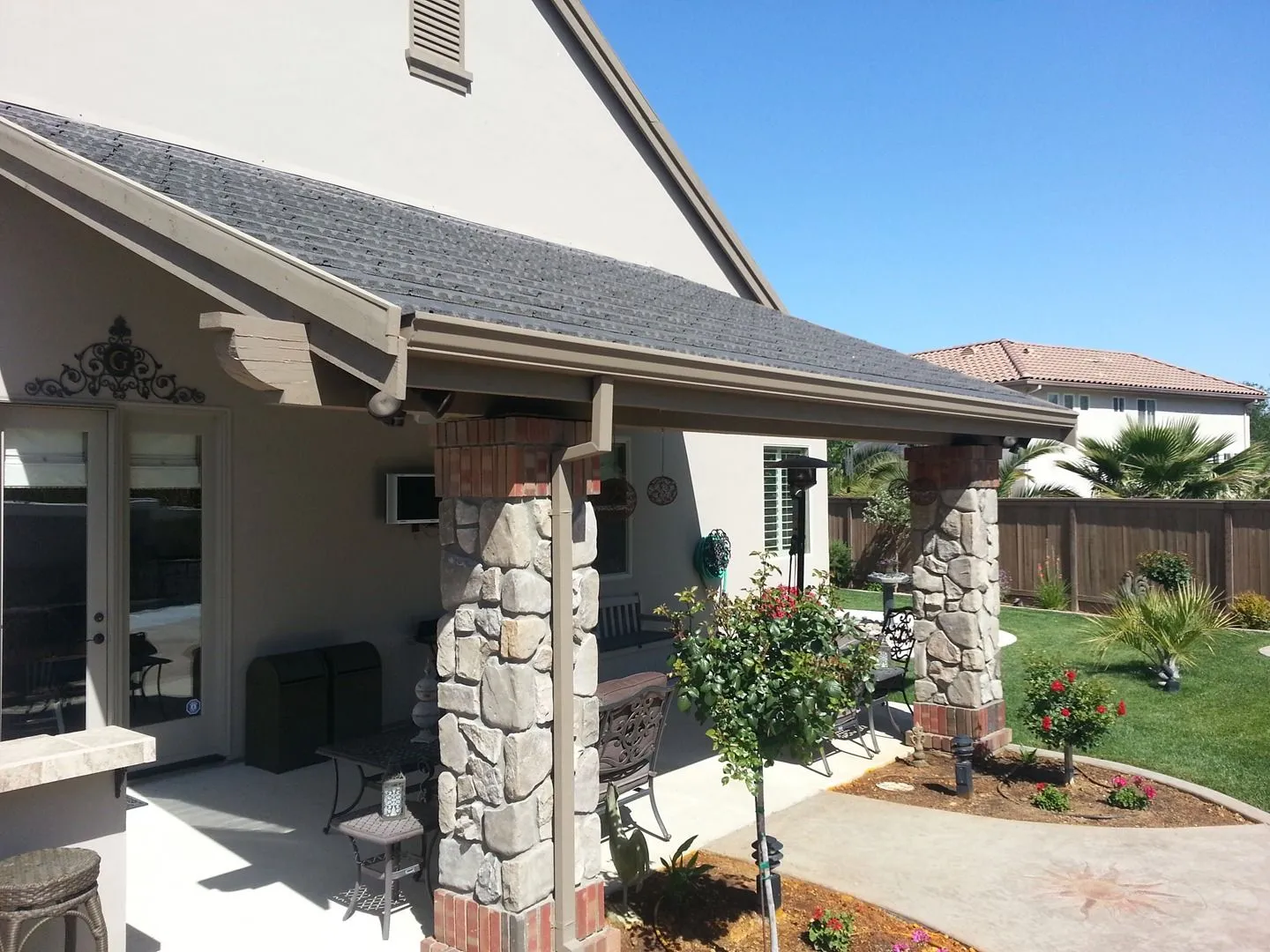 Covered patio with stone veneer columns over pavers