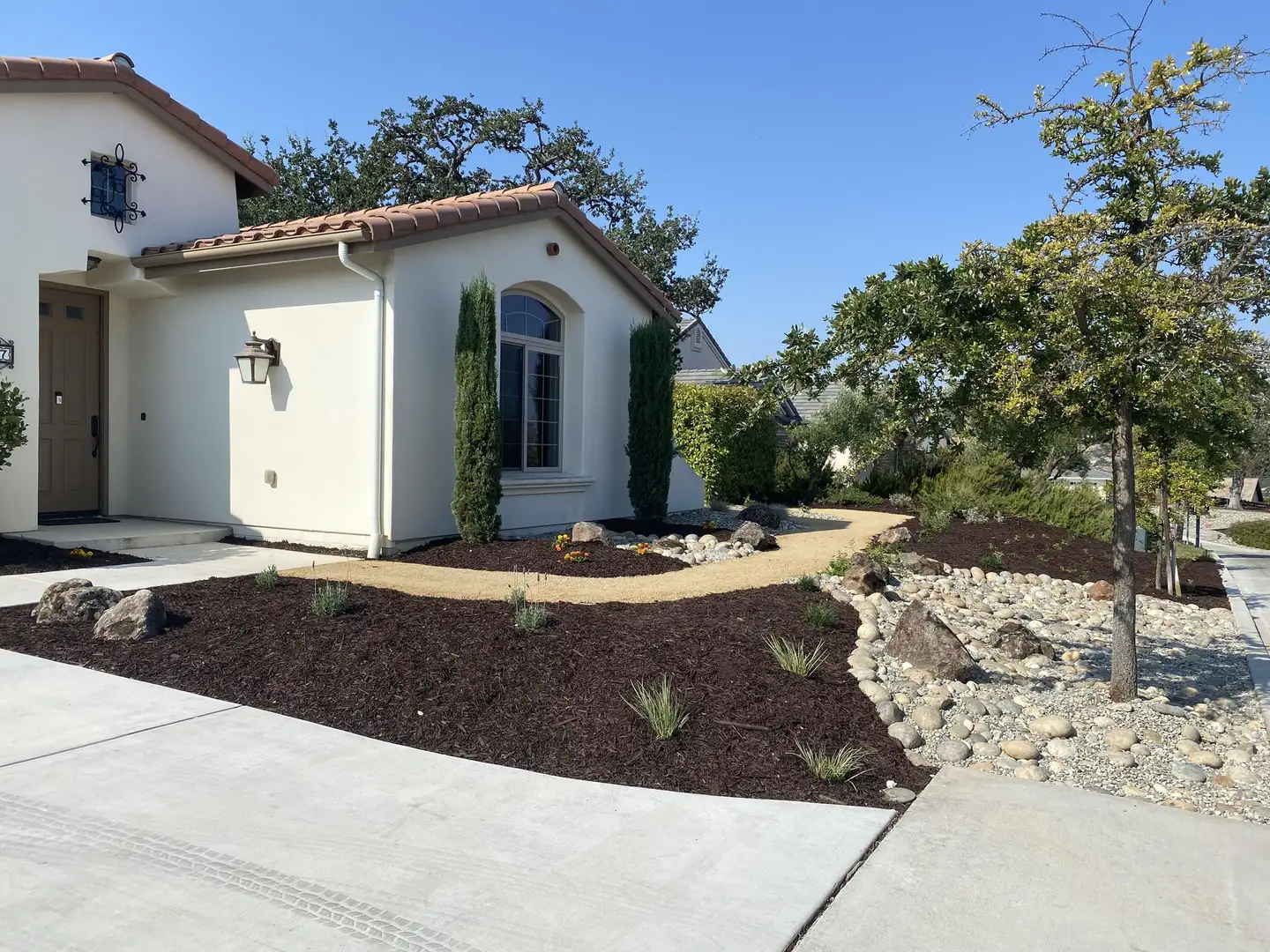 Front yard with a river rock swale and low planting