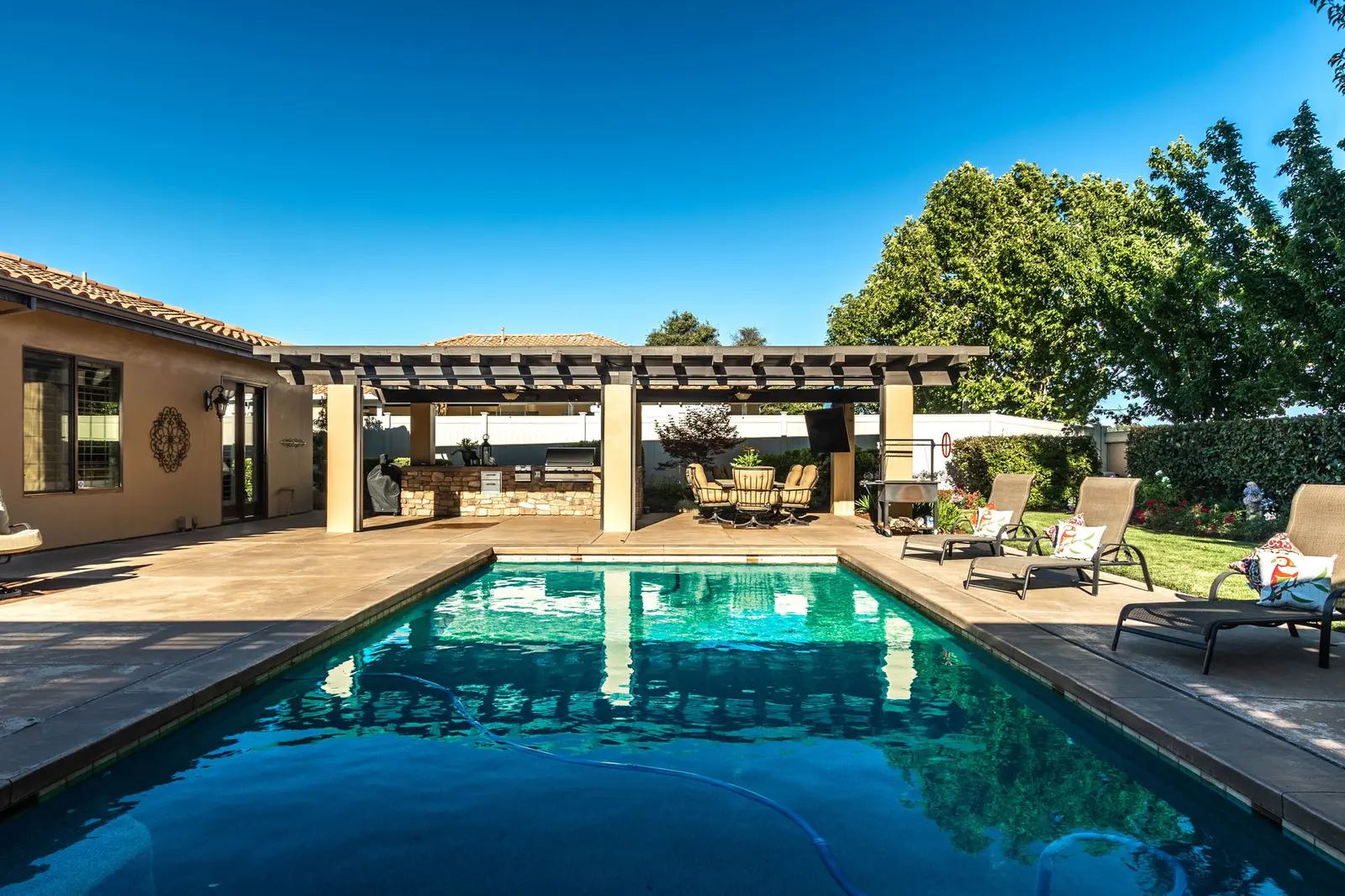 Rectangular pool beside a covered pavilion and patio