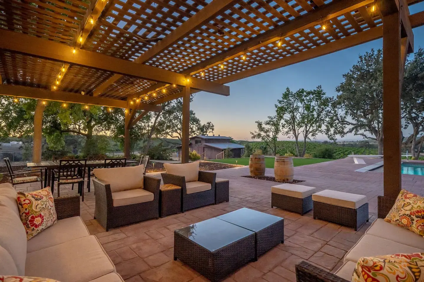 Timber pergola with string lights over a paver patio at dusk