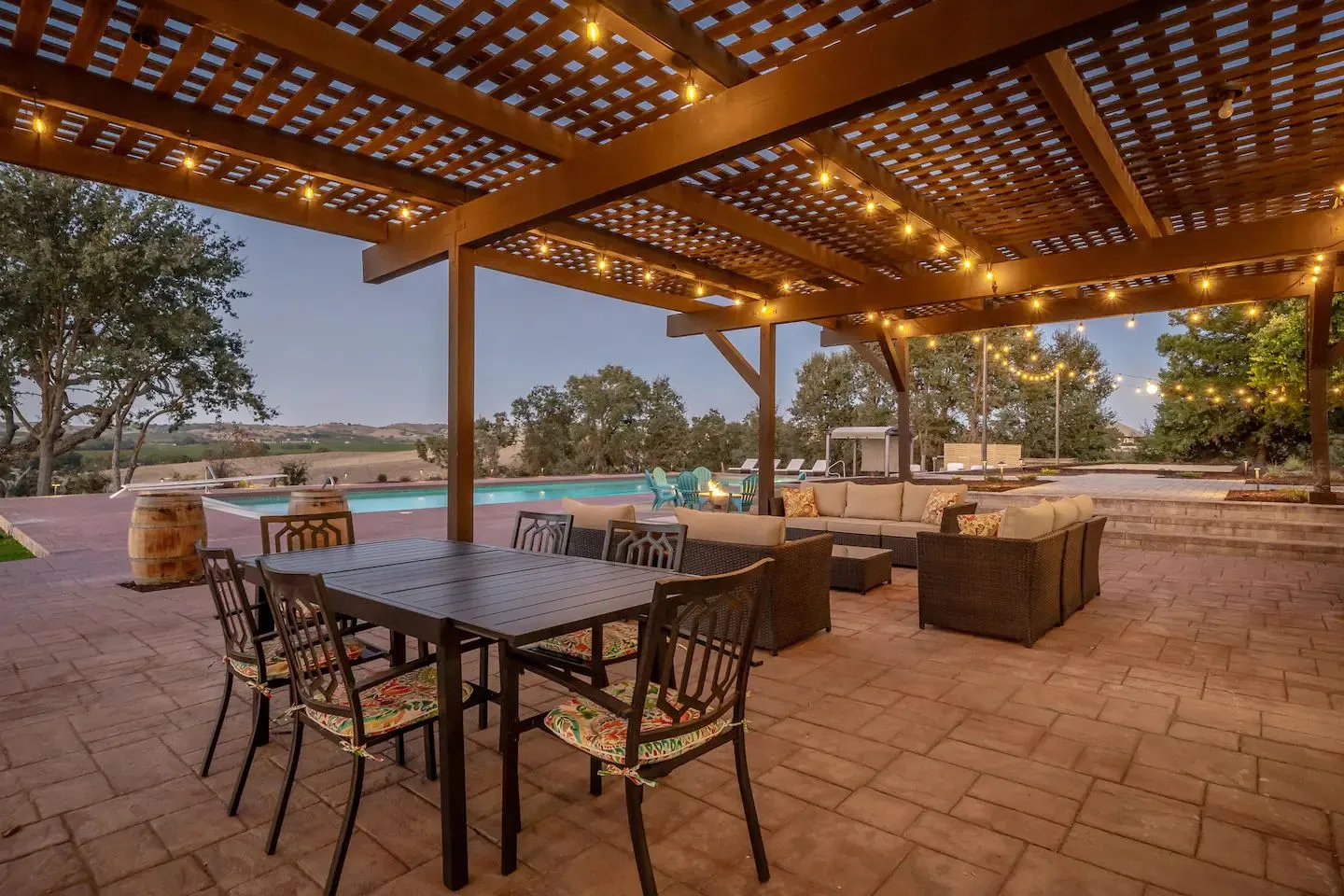 Timber pergola with string lights over a stamped concrete dining patio