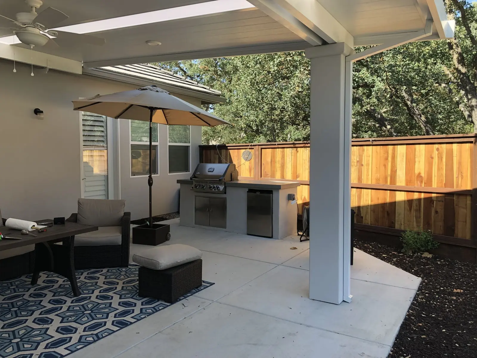 White aluminum patio cover over a furnished concrete patio