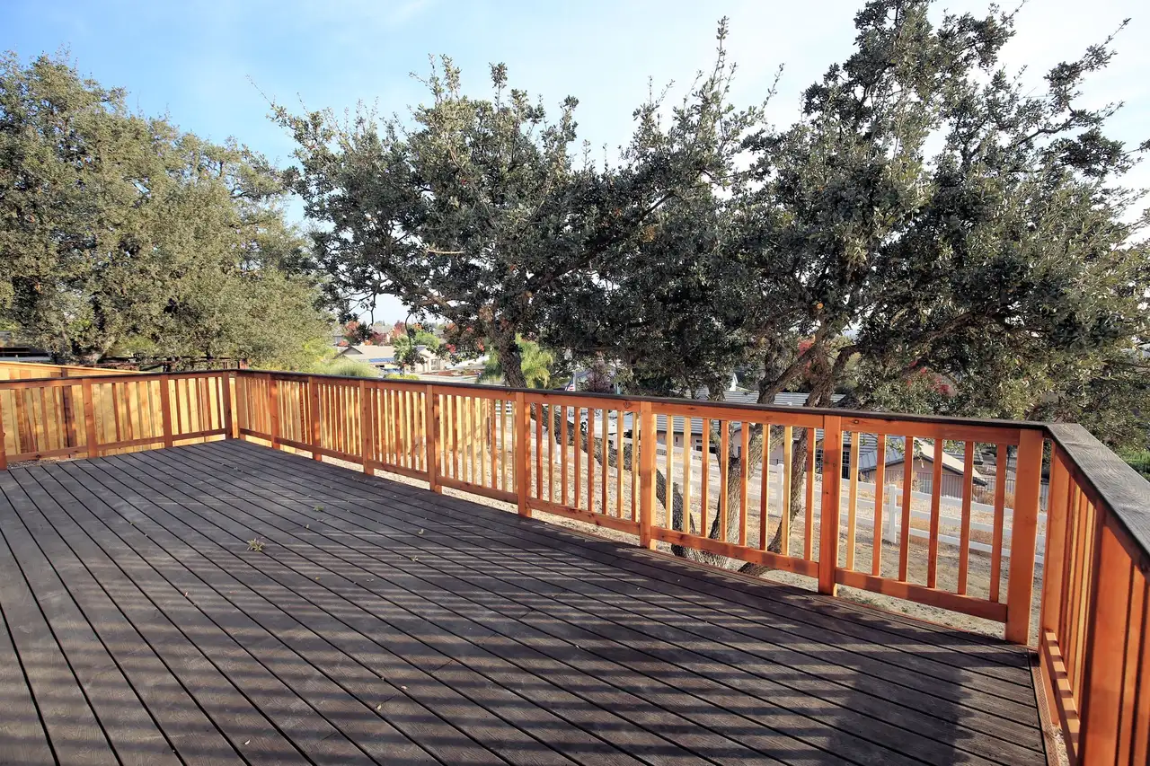 Wood deck with cedar railing among oak trees
