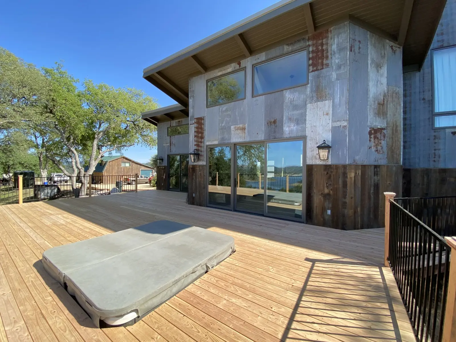 Wood deck with a covered hot tub beside a modern home
